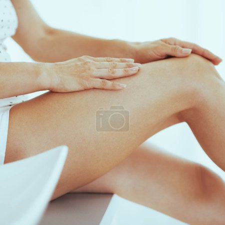 Foto de Primer plano de la mujer examinando la pierna en el baño - Imagen libre de derechos