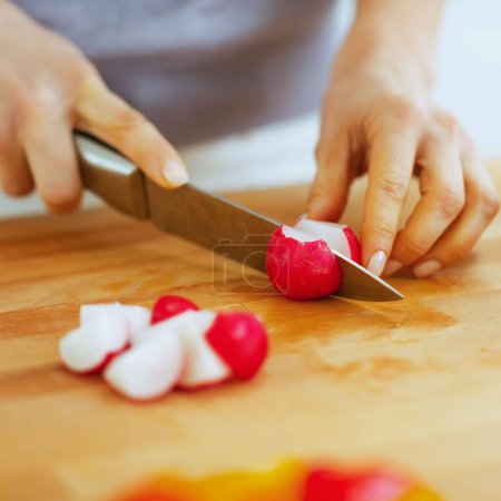 Photo for Closeup on woman cutting radishes on cutting board - Royalty Free Image