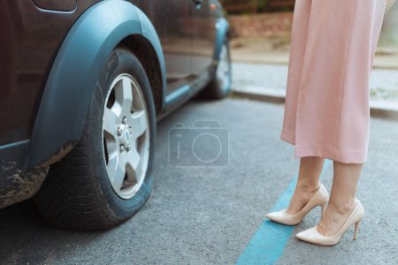 Photo for Car accident. Closeup on traveller woman in the city near car with flat tire. - Royalty Free Image