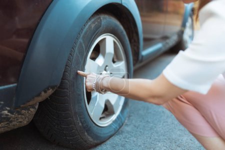 Photo for Car accident. Closeup on traveller woman in the city touching flat tire. - Royalty Free Image