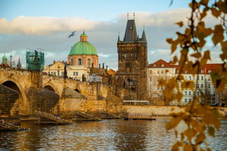 Téléchargez les photos : Paysage avec la rivière Vltava et Karlov la plupart dans la soirée tiré à travers le feuillage en automne à Prague, République tchèque. - en image libre de droit