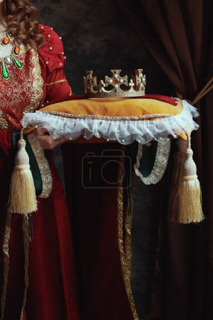 Photo for Closeup on medieval queen in red dress with crown on pillow. - Royalty Free Image