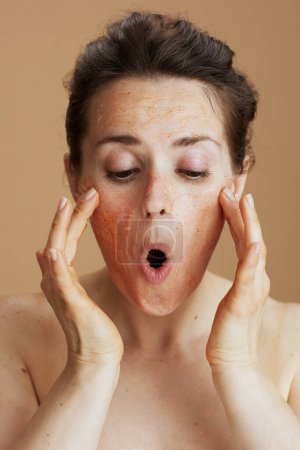 Téléchargez les photos : Jeune femelle avec gommage visage isolé sur beige. - en image libre de droit