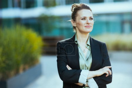 Photo for Pensive modern female worker in business district in black jacket with crossed arms. - Royalty Free Image