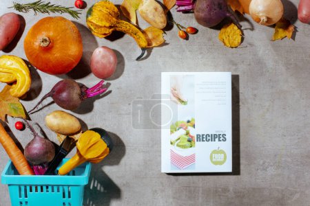 Photo for Autumn flat lay on a concrete background with cookbook, pumpkins, beetroot, autumn leaves, autumn leaf, consumer basket and autumn vegetables. - Royalty Free Image