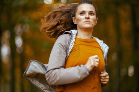 Foto de Hola otoño. mujer con estilo en ropa de fitness en el parque corriendo. - Imagen libre de derechos