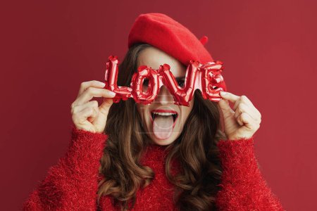 Téléchargez les photos : Joyeux Valentin. femme élégante gaie avec de longs cheveux ondulés en pull rouge et béret et inscription amour. - en image libre de droit