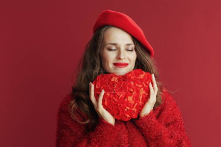 Foto de Feliz San Valentín. relajado elegante mujer de 40 años en suéter rojo y boina con corazón rojo. - Imagen libre de derechos