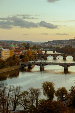 Foto de Paisaje con el río Moldava y Karlov más al atardecer a través del follaje en otoño en Praga, República Checa. - Imagen libre de derechos