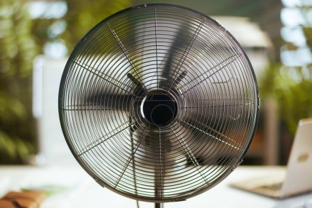 Téléchargez les photos : L'heure d'été. ventilateur métallique dans le bureau vert moderne. - en image libre de droit