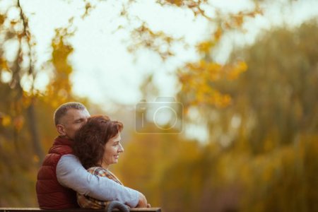 Photo for Hello autumn. happy modern couple in the park sitting on bench. - Royalty Free Image