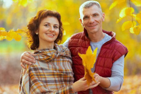 Foto de Hola otoño. Retrato de feliz pareja moderna en el parque con hojas de otoño. - Imagen libre de derechos