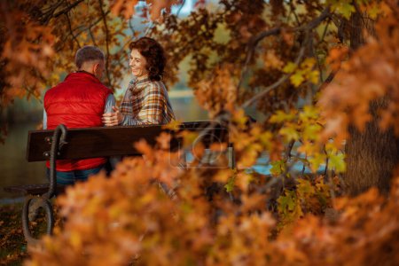 Téléchargez les photos : Bonjour l'automne. famille élégante souriante dans le parc assis sur le banc. - en image libre de droit