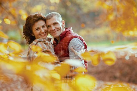 Foto de Hola otoño. Retrato de pareja moderna sonriente en el parque abrazando. - Imagen libre de derechos