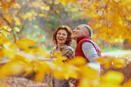 Foto de Hola otoño. sonriente pareja moderna en el parque caminando. - Imagen libre de derechos
