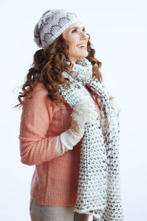 Téléchargez les photos : Bonjour l'hiver. heureux à la mode 40 ans femme en pull, mitaines, chapeau et écharpe isolé sur blanc. - en image libre de droit