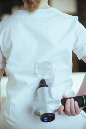 Photo for Healthcare time. Closeup on female medical massage therapist in spa salon with massage pistol. - Royalty Free Image