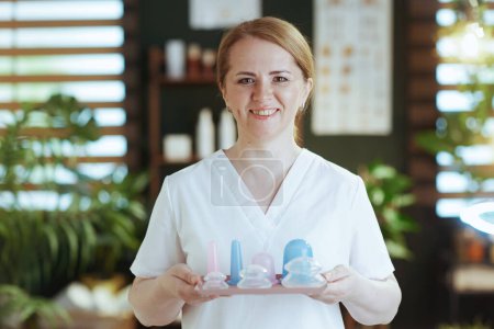 Photo for Healthcare time. Portrait of smiling female medical massage therapist in spa salon with vacuum therapy cup. - Royalty Free Image