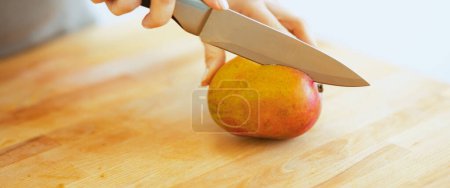 Foto de Primer plano de la mujer cortando mango - Imagen libre de derechos
