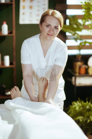 Téléchargez les photos : Temps de santé. massothérapeute dans l'armoire de massage masser les clients jambe. - en image libre de droit