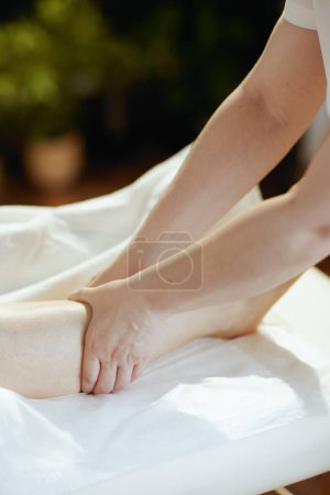 Téléchargez les photos : Temps de santé. Gros plan sur le massothérapeute médical dans l'armoire de massage massant les clients jambe. - en image libre de droit