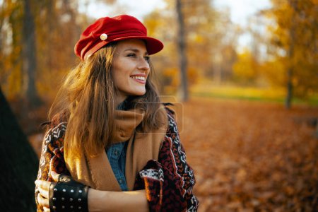 Foto de Hola otoño. feliz mujer elegante en sombrero rojo con bufanda y guantes en el parque de la ciudad. - Imagen libre de derechos