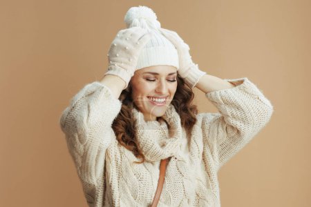 Photo for Hello winter. smiling stylish woman in beige sweater, mittens and hat isolated on beige. - Royalty Free Image