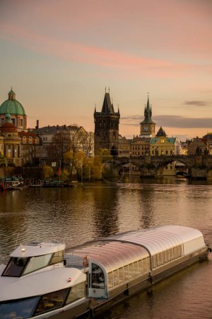Foto de Paisaje con el río Moldava, el puente de Carlos y el barco al atardecer en otoño en Praga, República Checa. - Imagen libre de derechos