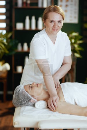 Photo for Healthcare time. medical massage therapist in massage cabinet massaging clients shoulder on massage table. - Royalty Free Image