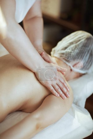 Téléchargez les photos : Temps de santé. Gros plan sur massothérapeute dans le salon de spa masser les clients de retour sur la table de massage. - en image libre de droit