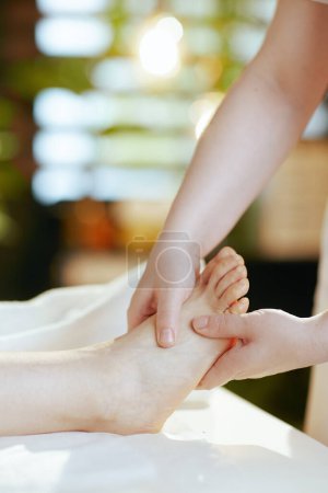 Téléchargez les photos : Temps de santé. Gros plan sur massothérapeute dans le salon de spa massant les pieds des clients. - en image libre de droit