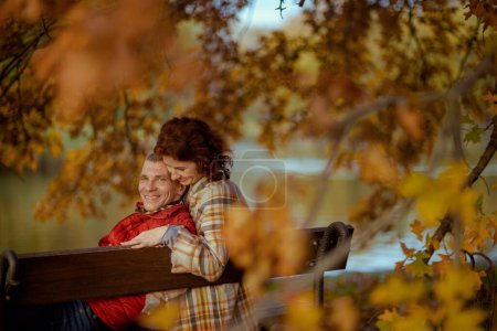 Téléchargez les photos : Bonjour l'automne. heureux couple élégant dans le parc assis sur le banc. - en image libre de droit