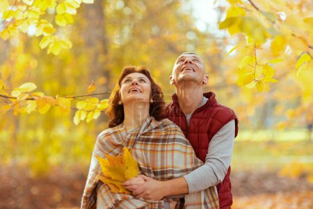Téléchargez les photos : Bonjour l'automne. heureux couple moderne dans le parc avec des feuilles d'automne levant les yeux. - en image libre de droit