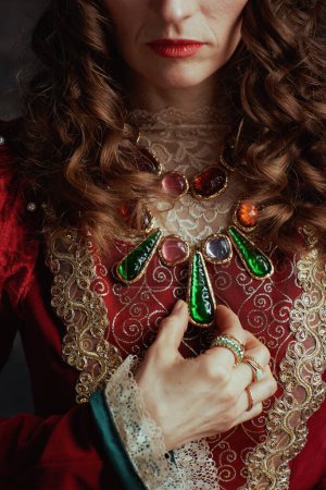 Téléchargez les photos : Gros plan sur la reine médiévale en robe rouge avec bijoux. - en image libre de droit