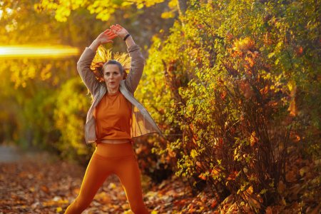 Foto de Hola otoño. mujer en forma en la ropa de fitness en el entrenamiento del parque. - Imagen libre de derechos