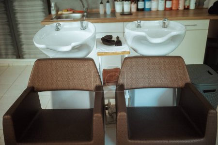 Téléchargez les photos : Studio de coiffure moderne avec chaises et unité de lavage de salon. - en image libre de droit