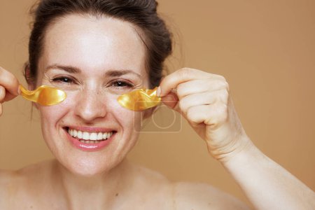 Téléchargez les photos : Jeune femelle souriante avec des bandeaux sur fond beige. - en image libre de droit