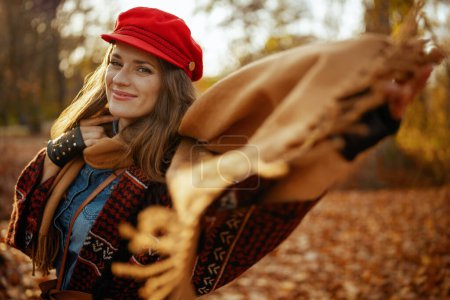 Téléchargez les photos : Bonjour l'automne. heureuse femme moderne en chapeau rouge avec écharpe et gants dans le parc de la ville. - en image libre de droit