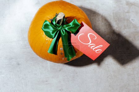 Photo for Autumn flat lay on a concrete background with pumpkins, sale tag and autumn leaf. - Royalty Free Image