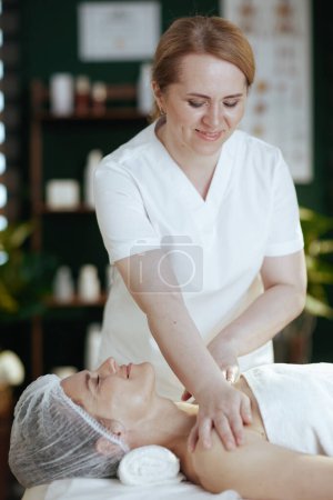 Foto de Tiempo de atención médica. masajista en salón de spa masajeando a los clientes hombro. - Imagen libre de derechos