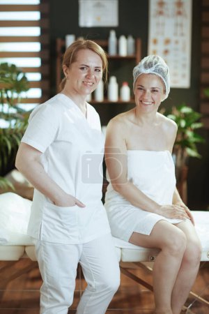 Photo for Healthcare time. massage therapist in spa salon with happy client on massage table. - Royalty Free Image