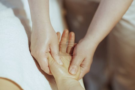 Téléchargez les photos : Temps de santé. Gros plan sur massothérapeute dans l'armoire de massage massant la main des clients. - en image libre de droit
