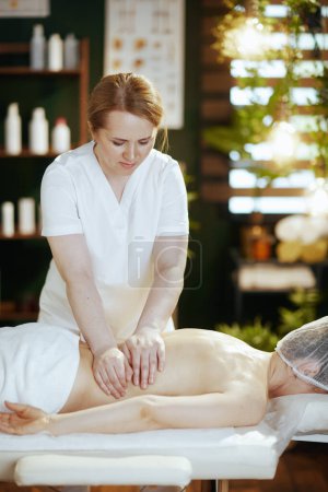 Foto de Tiempo de atención médica. masajista en salón de spa masajeando a los clientes de nuevo en la mesa de masaje. - Imagen libre de derechos