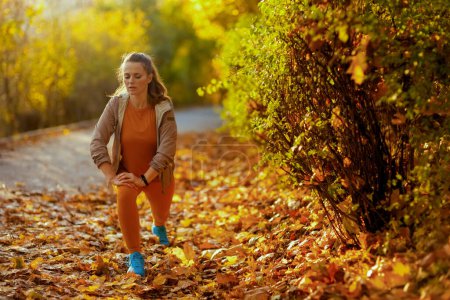 Photo for Hello autumn. elegant female in fitness clothes in the park stretching. - Royalty Free Image