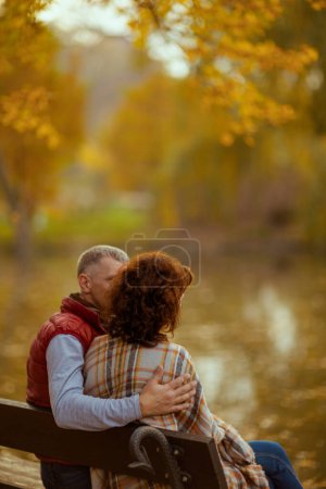 Téléchargez les photos : Bonjour l'automne. Vu de derrière famille romantique dans le parc assis sur le banc. - en image libre de droit