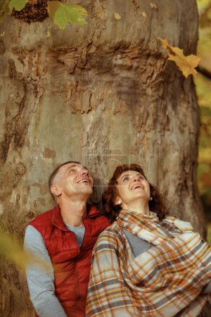Foto de Hola otoño. sonriente pareja moderna en el parque cerca del árbol. - Imagen libre de derechos