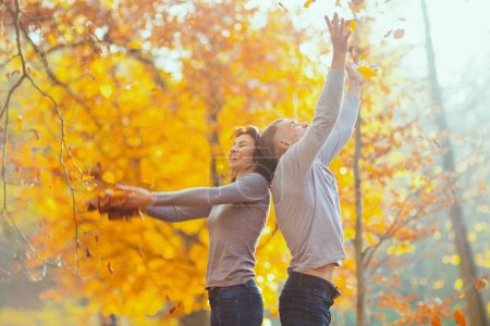 Foto de Hola otoño. feliz familia moderna en el parque lanzando hojas de otoño. - Imagen libre de derechos