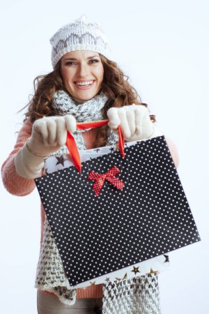 Foto de Hola invierno. sonriente mujer moderna en suéter, mitones, sombrero y bufanda aislados sobre fondo blanco con bolsas de compras. - Imagen libre de derechos