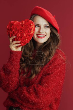 Téléchargez les photos : Joyeux Valentin. femme d'âge moyen moderne souriante en pull rouge et béret avec coeur rouge. - en image libre de droit