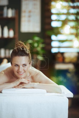 Téléchargez les photos : Temps de santé. heureuse femme moderne de 40 ans dans une armoire de massage posée sur une table de massage. - en image libre de droit